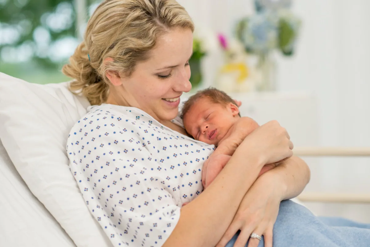 Hebamme mit Neugeborenem - Hygieneberatung für Entbindungseinrichtungen