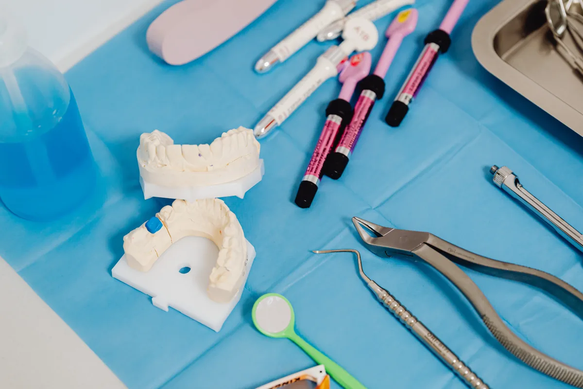 Instrumente auf blauem Tuch, Gebissmodell - Hygieneplan Zahnarztpraxis